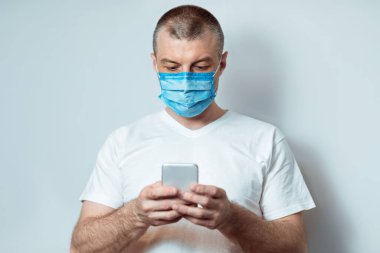 Karantina sırasında telefon kullanan maskeli adam, Gri Arkaplan