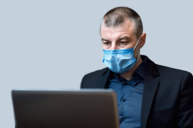 Stüdyoda Maskeli bir İşadamı Dizüstü bilgisayarla Stüdyoda Çalışıyor
