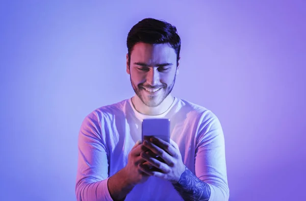 Bildschirm leuchtet auf Kerl, tippt Smartphone ein — Stockfoto