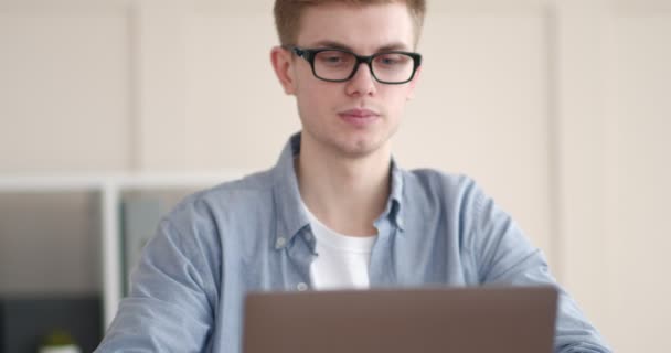 Ragazzo premuroso che si tiene per mano sul mento, lavorando a casa ufficio — Video Stock