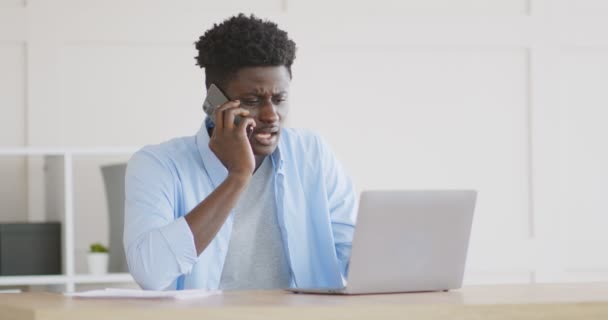 Enojado africano chico discutiendo con los empleados por teléfono — Vídeo de stock