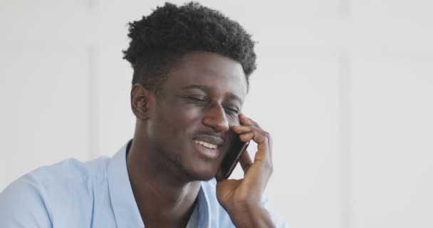 若いアフリカ系アメリカ人の男が家で携帯電話で話す — ストック動画