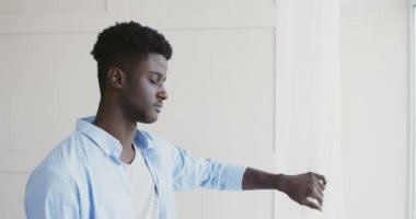 Canı sıkkın, Afro-Amerikan bir adam pencereden bakıyor.