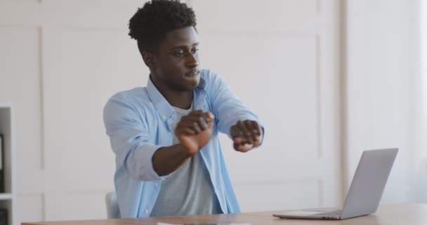 Happy emotional african american guy dancing near laptop — Stock Video