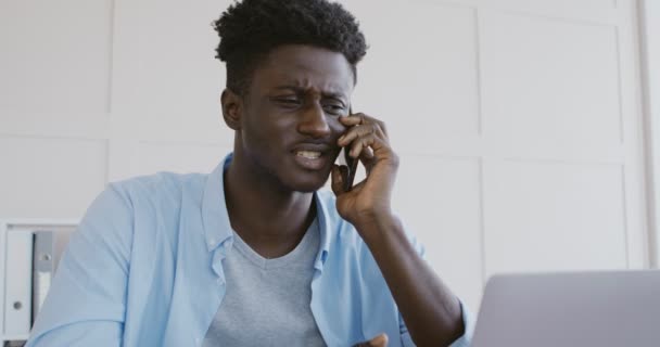 Empresario africano emocional discutiendo con socios por teléfono — Vídeo de stock