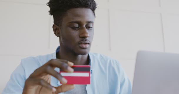 젊은 아프리카 계 미국인 노트북으로 신용 카드 데이터를 입력 — 비디오