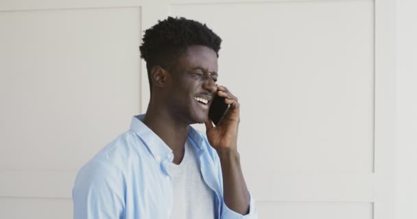 Vrolijke Afrikaan amerikaanse man praten met vrienden via de telefoon — Stockvideo