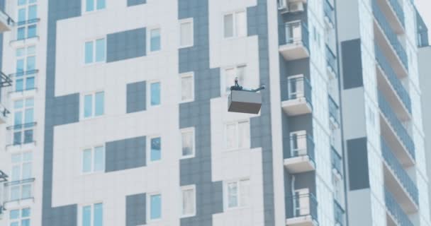 Drone con paquete volando a edificio residencial — Vídeo de stock