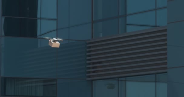 Drone with postal package flying through glass buildings — Stock Video