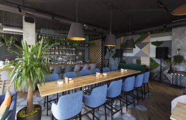Koltukları ve ahşap masaları olan şirin bir restoran.