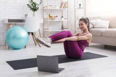 Kilitleme faaliyetleri. Antrenman videolarını takip eden genç bir kız.