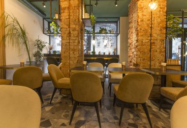 Koltukları ve ahşap masaları olan şirin bir restoran.