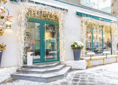 Işıkları ve karlı asfaltı olan bir kafeye.