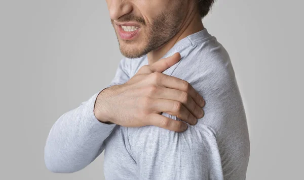 Man face expresses pain. Guy has Inflammation in shoulder — Stock Photo, Image