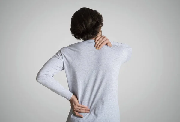 Unavený muž cítí bolest v krku a zádech — Stock fotografie