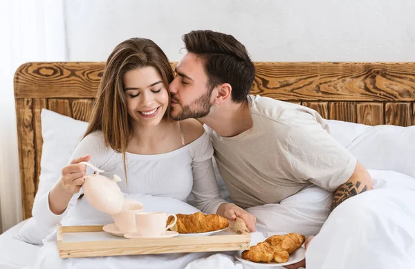 Man kust vrouw op wang gelukkig vrouw schenkt koffie — Stockfoto