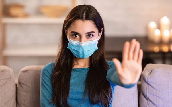 Nő visel sebészeti maszk mutató stop kéz gesztus — Stock Fotó
