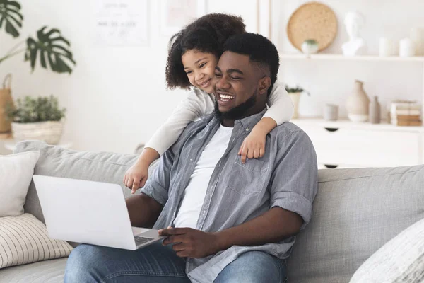 Online winkelen. Vrolijke zwarte vader en dochter met behulp van laptop thuis — Stockfoto