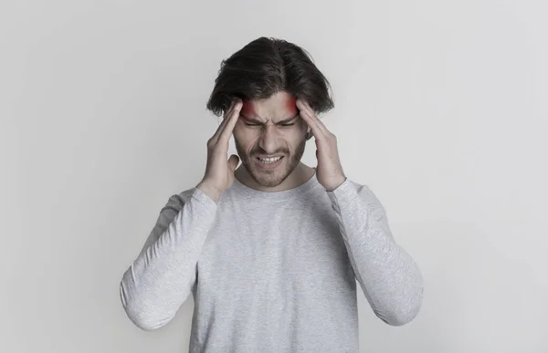 Man holds on to head, highlighted by red spots — Stock Photo, Image