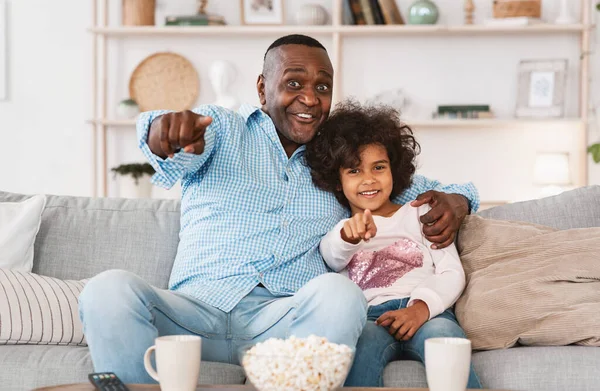 家庭电影院。非洲裔美国人的祖父和孙子孙女一家人一起在室内看电视 — 图库照片