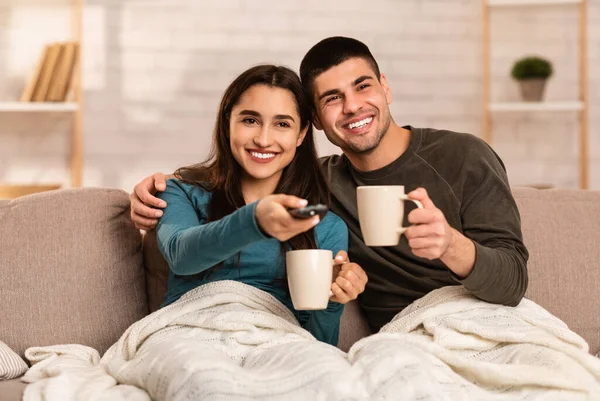 Casal sentado no sofá e assistindo tv — Fotografia de Stock