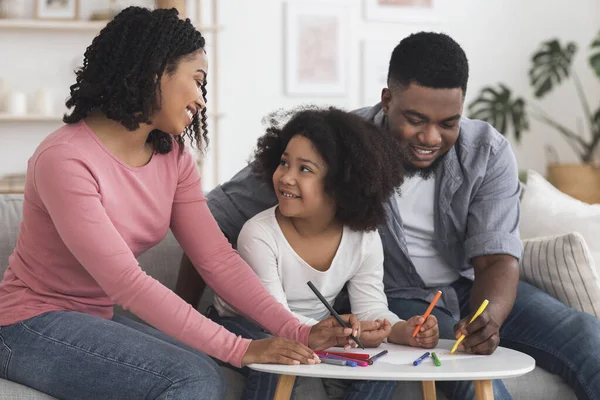 Gelukkig zwart ouders tekenen met hun weinig dochter thuis — Stockfoto