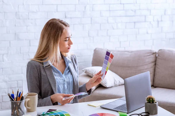 Vrouw met kleurstalen en laptop aan het werk tijdens epidemie — Stockfoto