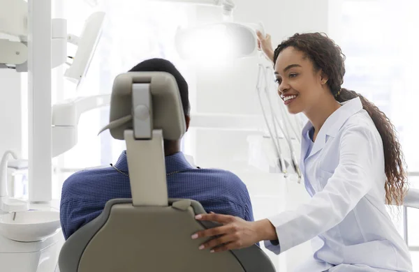 Vennlig svart kvinnelig stomatolog hilser pasienten – stockfoto