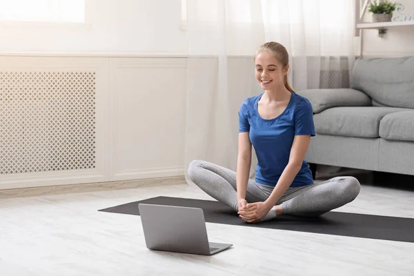 Молода жінка медитує біля ноутбука вдома, порожній простір — стокове фото