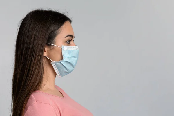 Conceito de Coronavírus. Retrato da vista lateral da mulher na máscara médica protetora — Fotografia de Stock