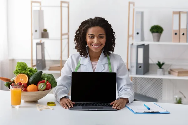 빈 노트북 화면을 보여 주는 행복 한 여성 영양학 자 — 스톡 사진
