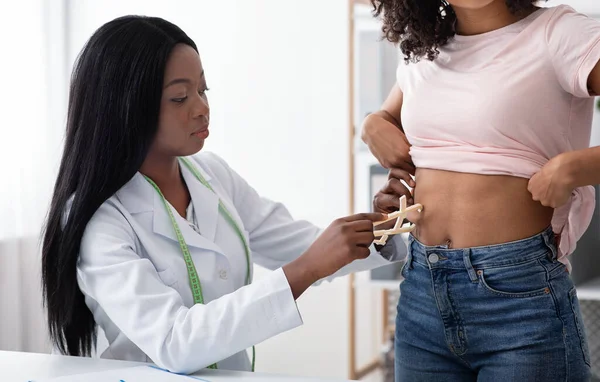 Dietary doctor checking body fat index with caliper