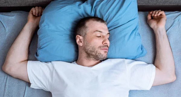 Muž spí a chrápání ležící v posteli v ložnici, top-View — Stock fotografie