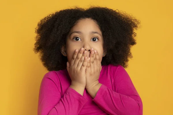 Retrato de assustada menina negra cobrindo a boca com as mãos — Fotografia de Stock