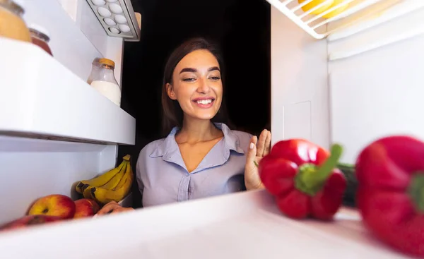 Femme heureuse prenant des légumes frais du réfrigérateur — Photo