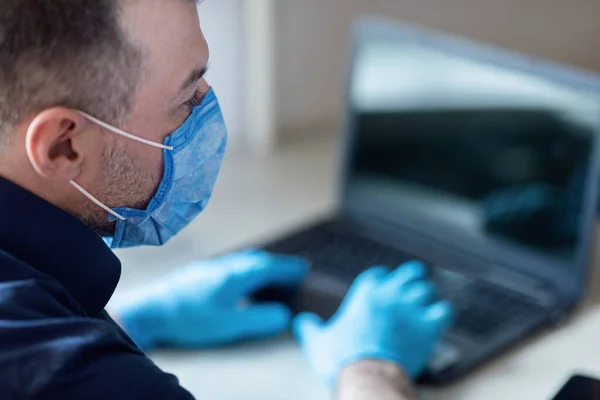 Biznesmen siedzi na laptopie Praca z domu noszenie maski medycznej — Zdjęcie stockowe