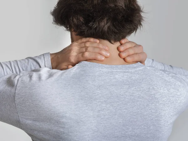 Neck pain concept. Man rubs sore spot — Stock Photo, Image