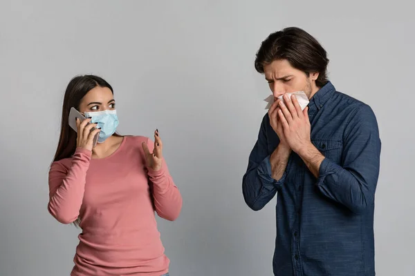 Bekymrad kvinna i medicinsk mask talar på mobilen bredvid sjuk pojkvän — Stockfoto