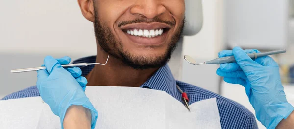 Fechar as mãos do dentista com ferramentas e paciente sorridente — Fotografia de Stock