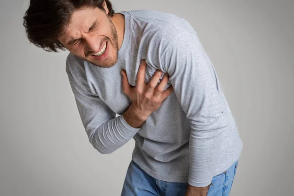 Біль сильний, чоловік притискає пальці до грудей — стокове фото