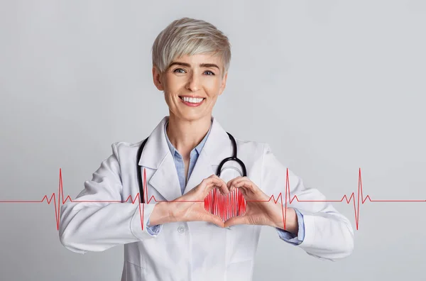 Cardiology concept. Female doctor showing heart with her hands and cardiogram on grey background, collage