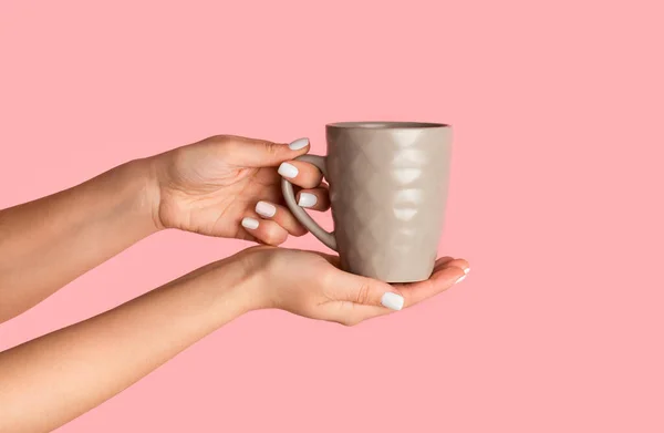 Ragazza millenaria che tiene la tazza con gustosa bevanda calda su sfondo rosa, primo piano — Foto Stock