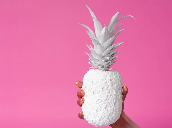Kéz fogja fehér ananász rózsaszín háttér — Stock Fotó