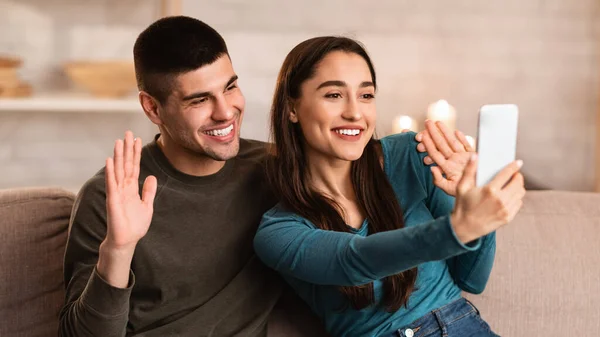 Feliz casal encantador fazendo chamada de vídeo no telefone em quarentena — Fotografia de Stock