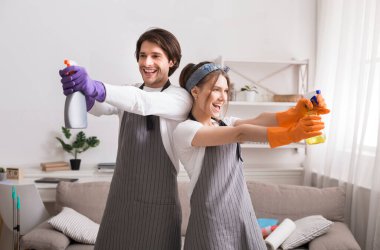 Apartmanı temizlerken deterjan püskürtücülerini hedef alan komik genç çift.