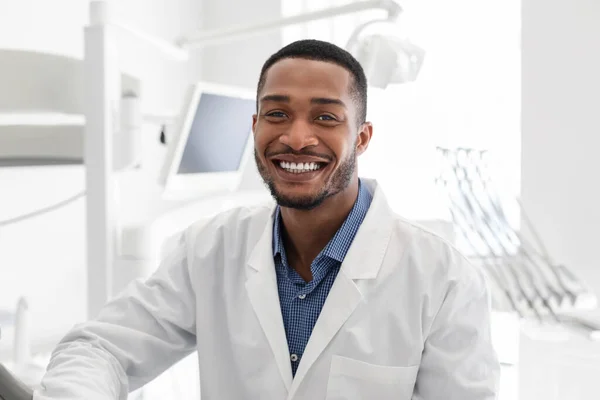 Yakışıklı Afrikalı dişçi, dişçi kliniğinde gülümsüyor. — Stok fotoğraf