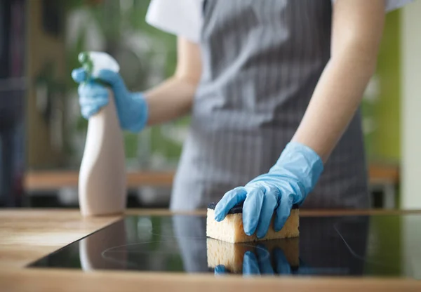 Mujer irreconocible limpiando cocina en guantes con spray desinfectante — Foto de Stock