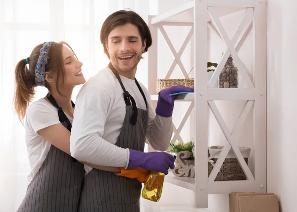 Casal romântico jovem fazendo trabalhos domésticos em casa juntos, abraçando e sorrindo — Fotografia de Stock