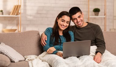 Koltukta bilgisayar kullanan bir çift.