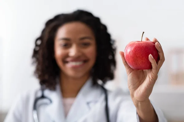 Pomme rouge fraîche dans la main du médecin, mise au point sélective — Photo